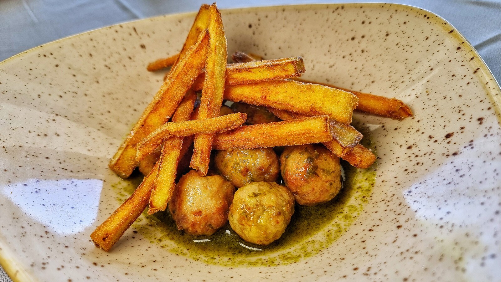 Las albóndigas de corvina en salsa verde y berenjenas fritas. Foto: Salva Moreno