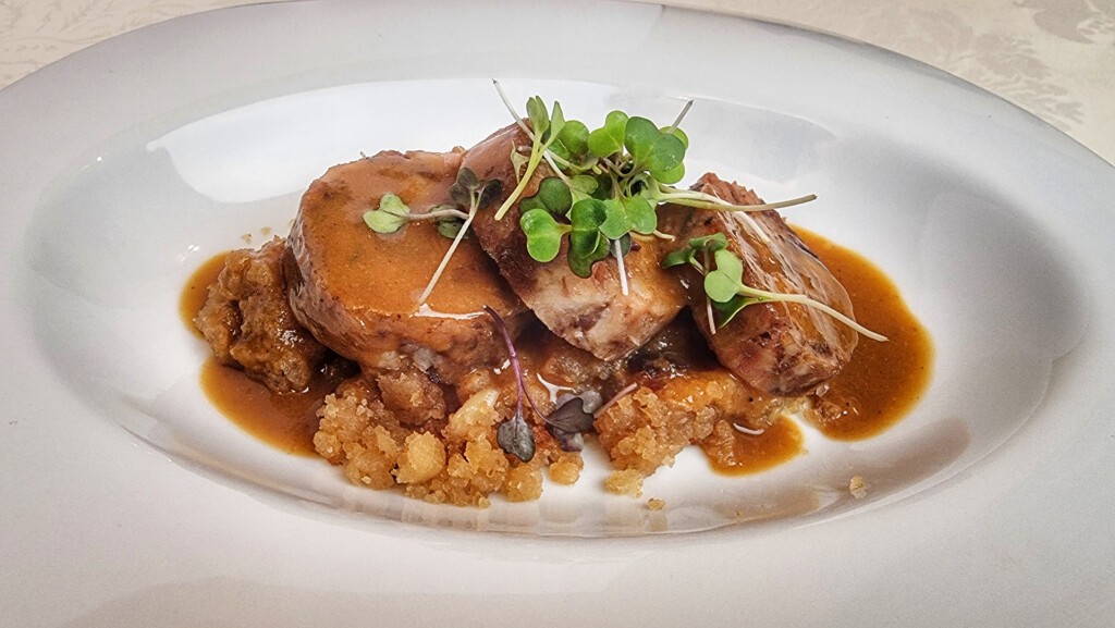 Rulo de cerdo ibérico glaseado sobre migas de Almonaster. Foto: Salva Moreno