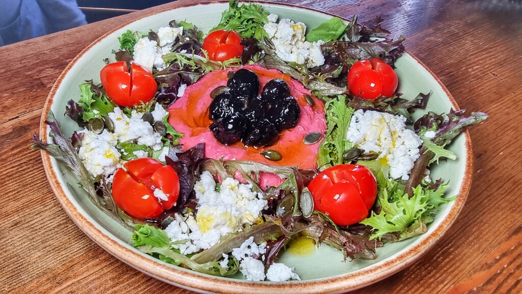 La ensalada Palmyra, con hummus de remolacha, pipas de girasol, lechuga, tomate cherry, feta y aceitunas beldi. Foto: Salva Moreno 