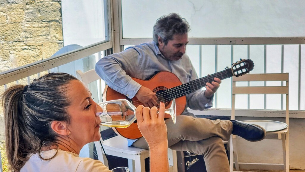 Música de primera, amontillado y Vejer. ¿Quién da más? 6 Una asistente a la cata, degustando el amontillado mientras Nono García actúa. Foto: Salva Moreno
